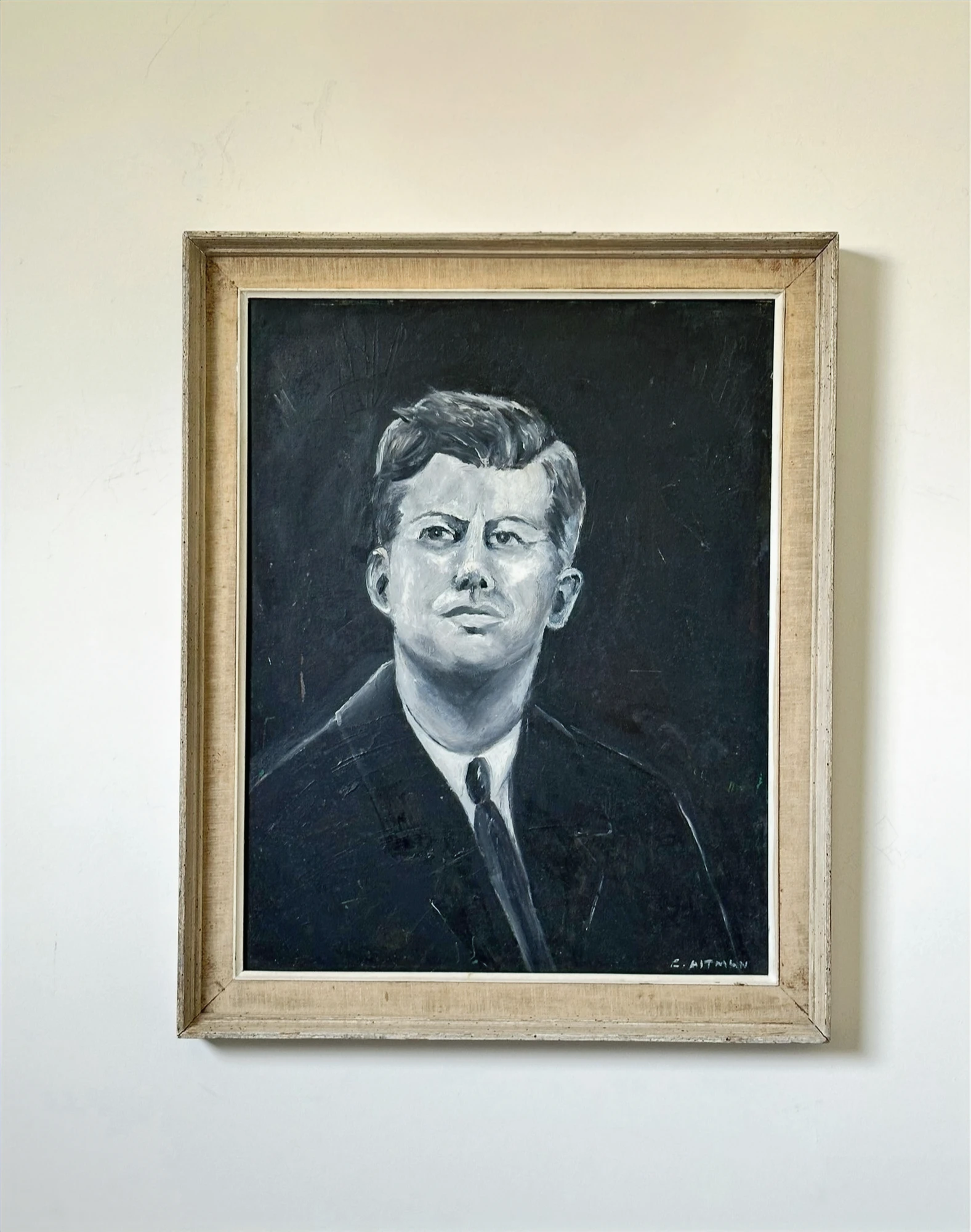 A monochrome portrait of John F. Kennedy wearing a dark suit and tie against a dark background. John F. Kennedy, by Evelyn Altman.