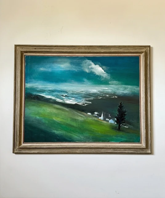 A coastal valley with green hills, dark trees and a small church beneath a sweeping blue and white sky. Church in The Valley, by Evelyn Altman.