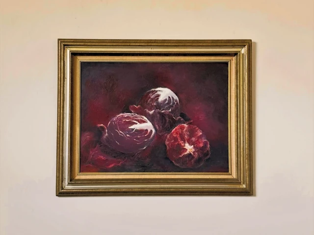 Three deep purple cabbages with pale curling leaves against a dark burgundy background. Cabbages, by Evelyn Altman.