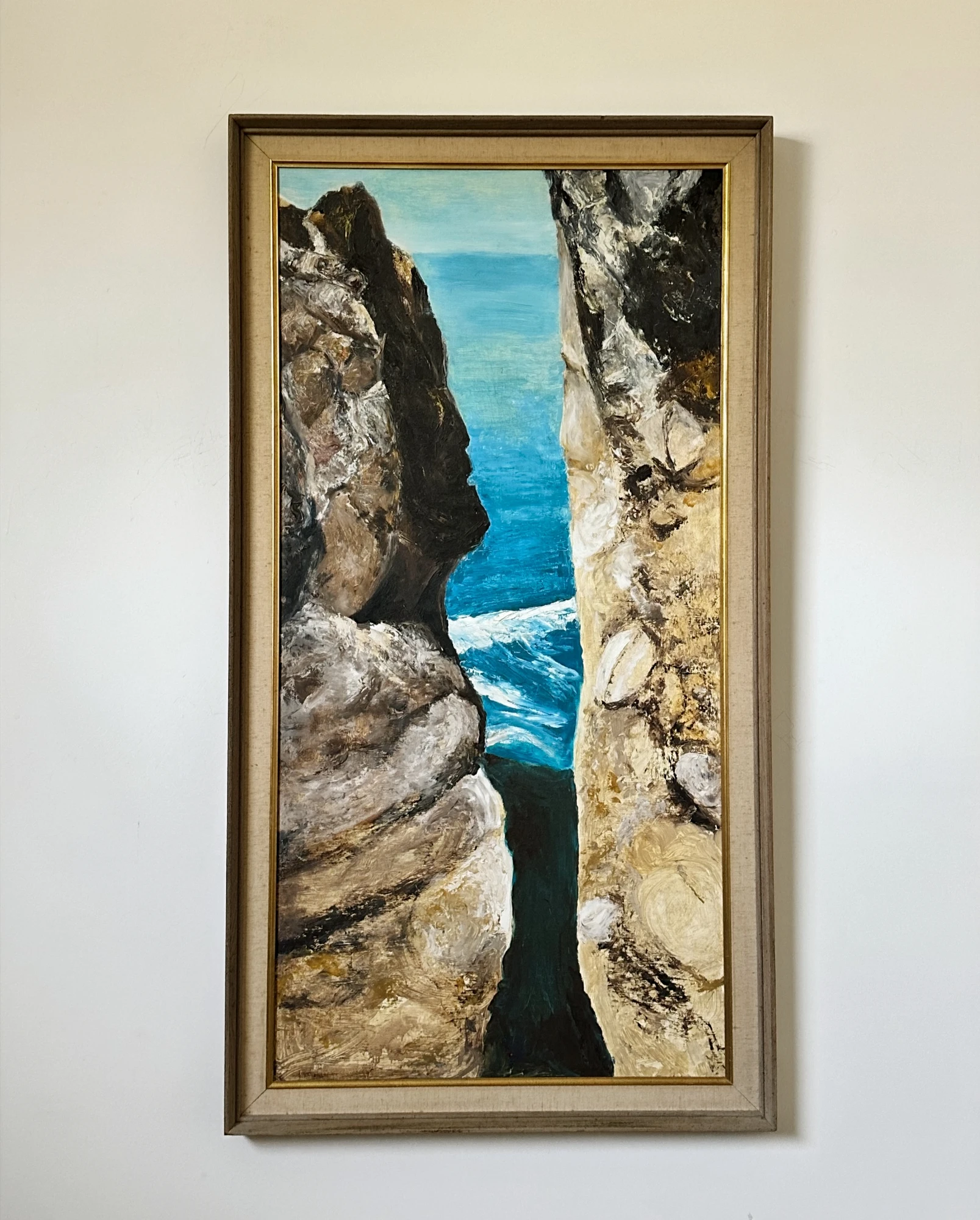 Turquoise sea glimpsed through a narrow opening between towering gray coastal cliffs. Near Devils Slide, by Evelyn Altman.