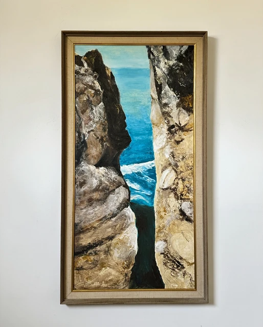 Turquoise sea glimpsed through a narrow opening between towering gray coastal cliffs. Near Devils Slide, by Evelyn Altman.