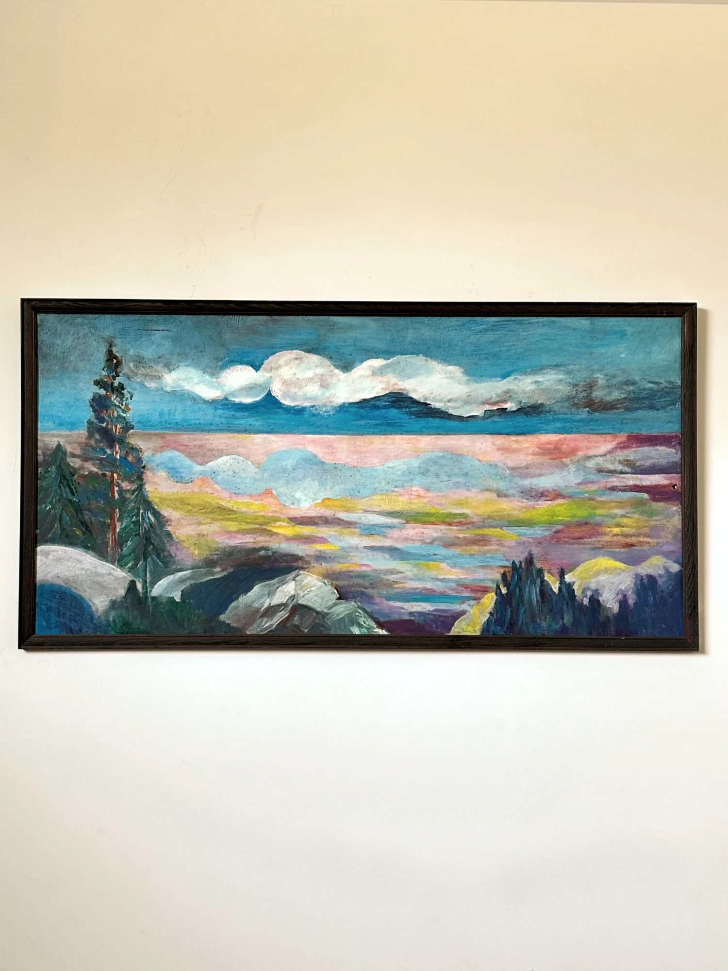 A long mountain panorama with an evergreen tree, pale rocks and layered bands of sunset clouds. Panoramic Dreams, by Evelyn Altman.