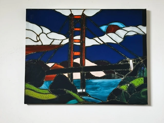The red towers of the Golden Gate Bridge amid blue water, white clouds and dark outlined geometric shapes. Golden Gate Bridge, by Evelyn Altman.
