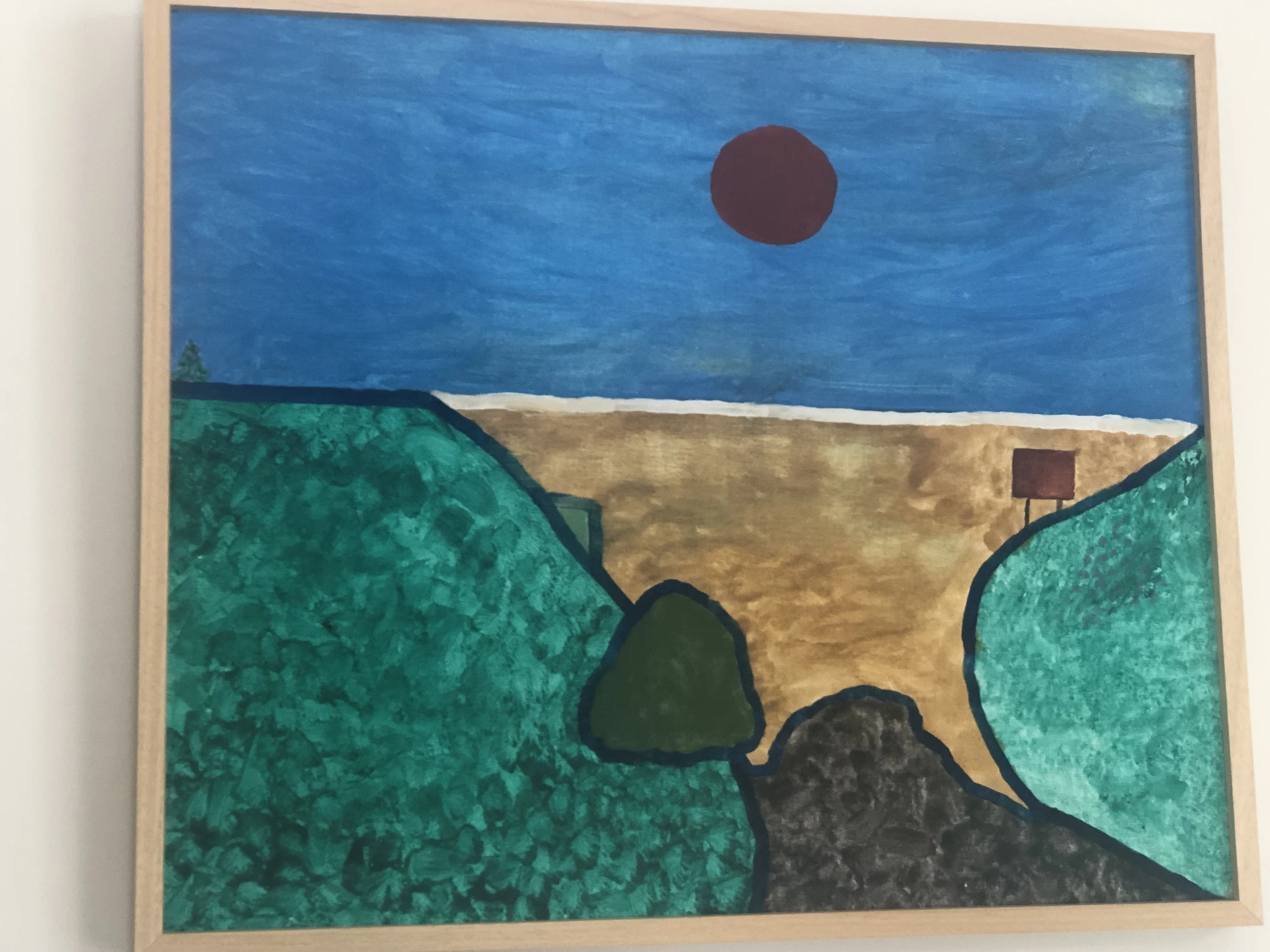 A red sun over a deep blue ocean, with a sandy inlet between broad green headlands. Twilight Over The Ocean, by Laida Altman.