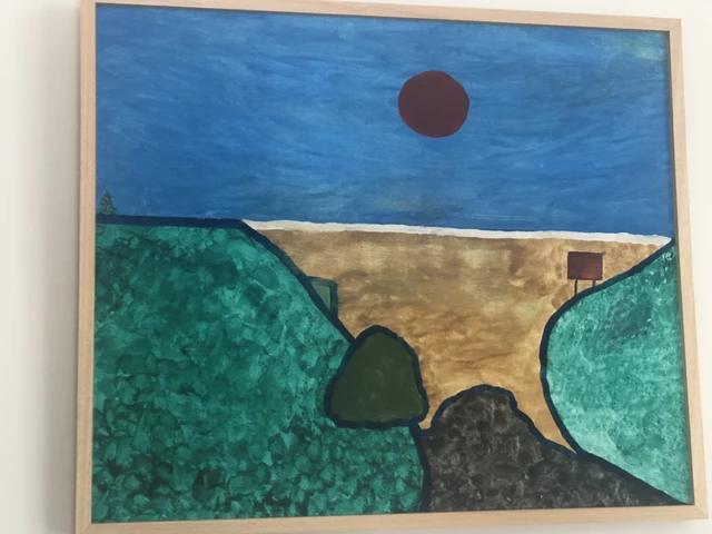 A red sun over a deep blue ocean, with a sandy inlet between broad green headlands. Twilight Over The Ocean, by Laida Altman.